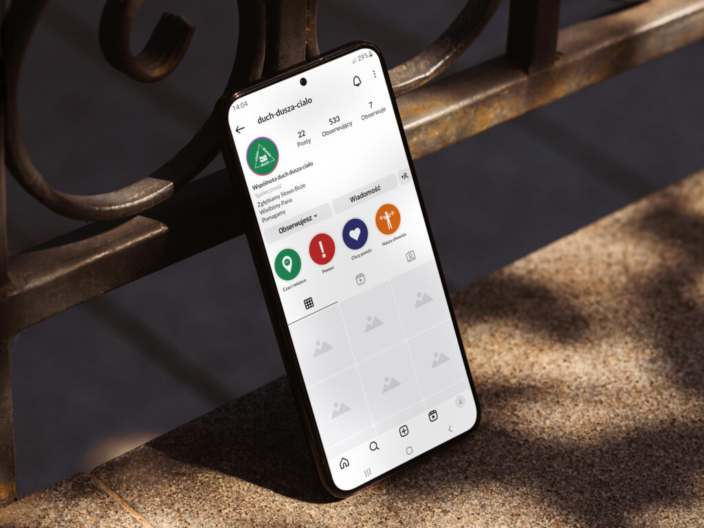 Wizualizacja logo jako zdjęcia profilowego i ikonek na Instagramie. Profil Instagram na ekranie smartfona opartego o poręcz.