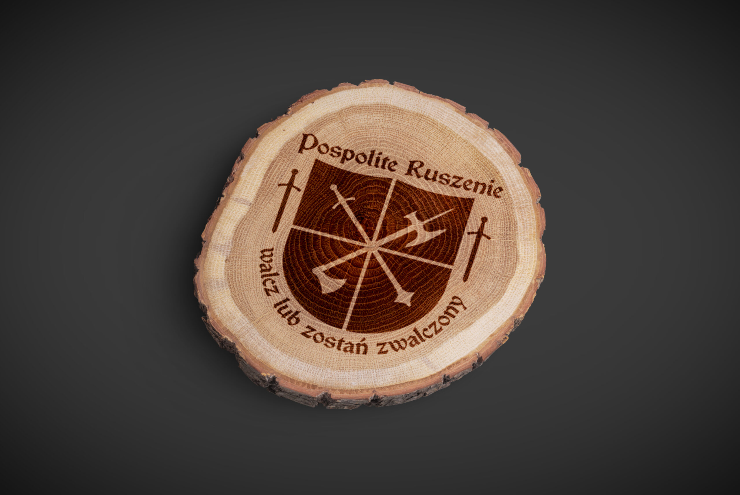 Prezentacja logo Pospolitego Ruszenia – logo wypalone na kawałku drewna.
