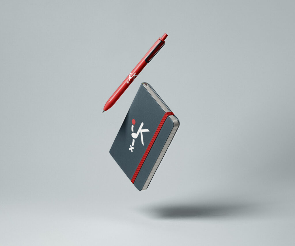 Prezentacja logo studia Kind Records – sygnet na długopisie i notesie.